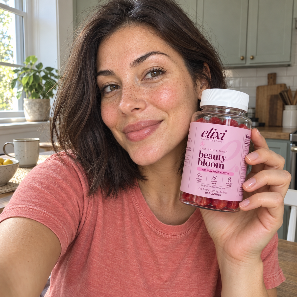 Woman holding Beauty Bloom gummies in her kitchen