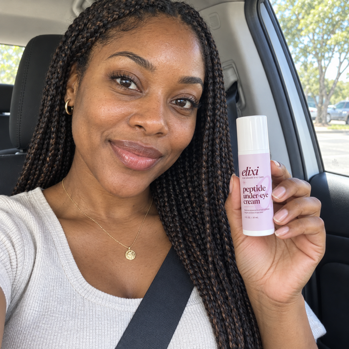 Woman with braids holding Elixi Peptide Under-Eye Cream in a car