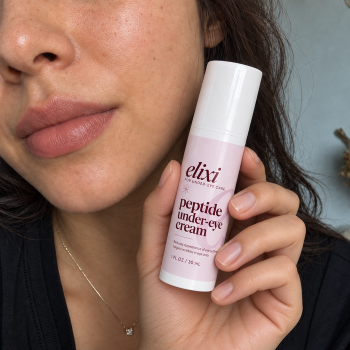 Close-up of a woman holding Elixi Peptide Under-Eye Cream