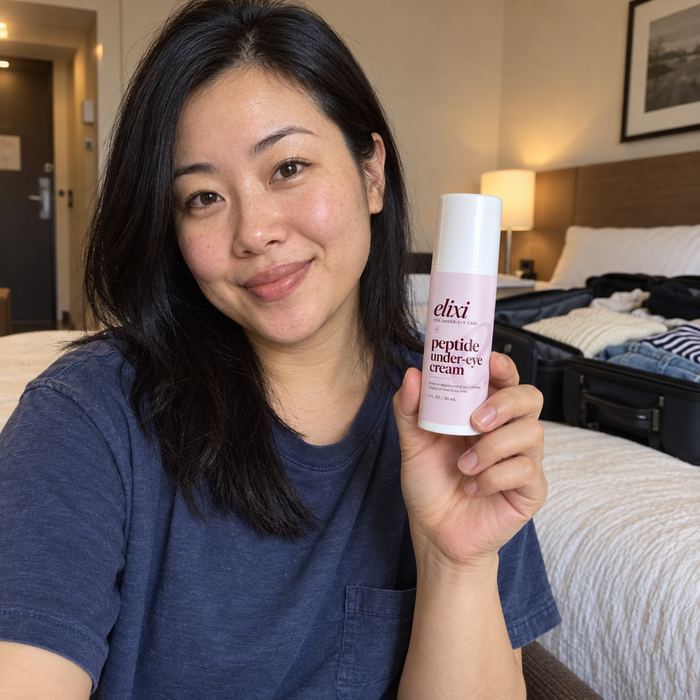 Woman holding Elixi Peptide Under-Eye Cream in a hotel room