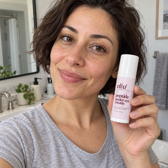 Woman with short brown hair holding Elixi Peptide Under-Eye Cream