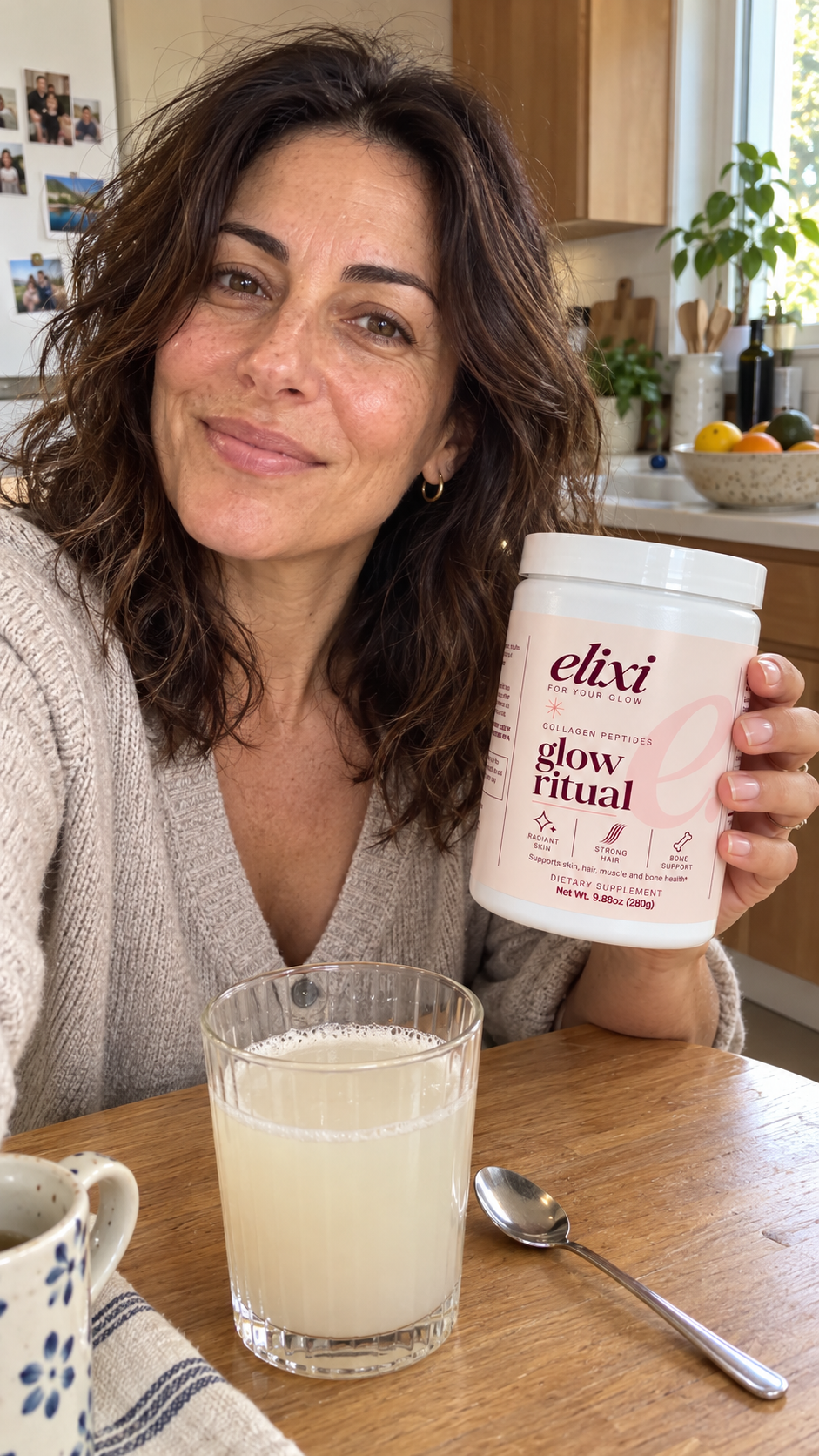 Woman holding Elixi Glow Ritual collagen peptides beside a glass in her kitchen