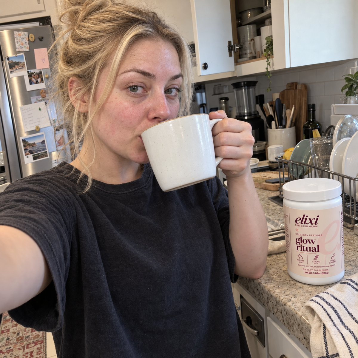 Woman drinking from a mug with Glow Ritual on the kitchen counter